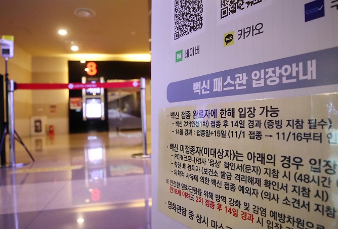 A sign set up at a movie theater in Seoul on Dec. 5, 2021, provides information on the vaccine pass requirements. (Yonhap)