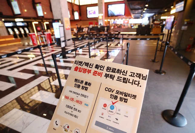 In this file photo taken Dec. 5, 2021, a sign at a Seoul movie theater asks people for their identity verification. (Yonhap)