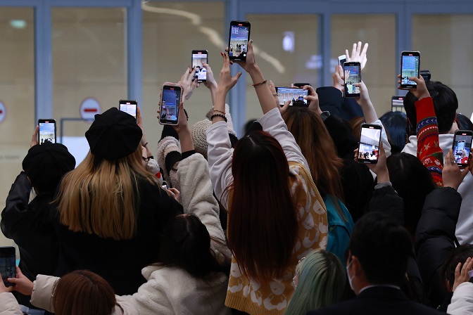 Fans take photos of BTS arriving at Incheon International Airport, west of Seoul, on Dec. 6, 2021, after a trip to the United States for the septet's concerts at SoFi Stadium in Los Angeles. (Yonhap)