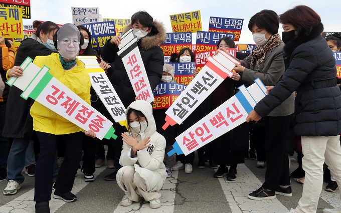 Civic groups deliver a performance calling on the government to withdraw its decision to extend COVID-19 vaccine pass requirements to teenagers in front of the Korea Disease Control and Prevention Agency headquarters in the central city of Cheongju. (Yonhap)