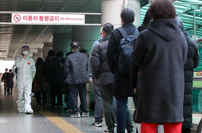 People line up at a makeshift clinic in central Seoul on Dec. 21, 2021 to get tested for COVID-19. (Yonhap)