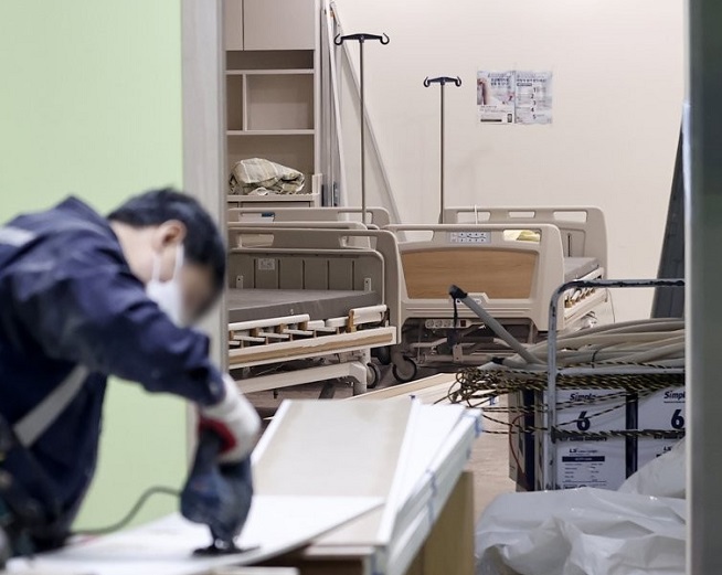 A worker engages in woodwork at Hyemin Hospital, a facility only for patients infected with the new coronavirus, in Seoul on Dec. 22, 2021, to transform an intensive care unit into a negative pressure ward. (Yonhap)