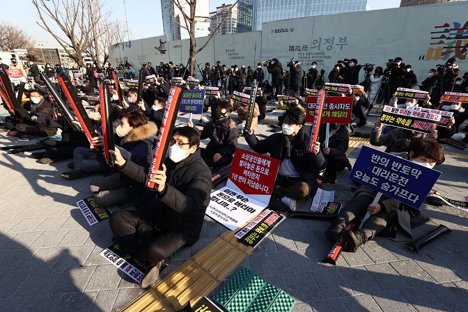 Owners of restaurants, cafes and other small businesses hold a rally in downtown Seoul against the government's reimposing of tougher virus rules, business curfews and the controversial vaccine pass system on Dec. 22, 2021. (Yonhap)