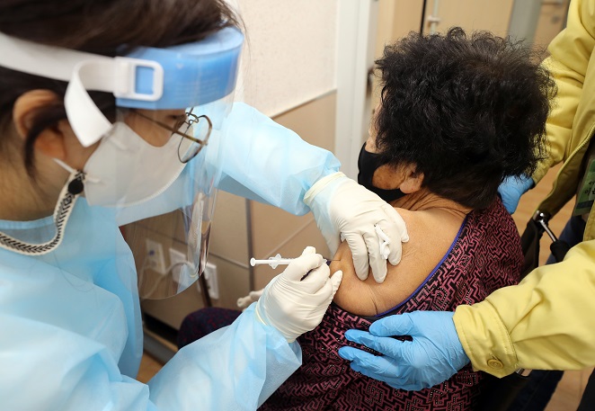 This photo taken on Dec. 24, 2021, shows an elderly woman receiving a COVID-19 booster shot at a mobile vaccine bus clinic in Gokseong, South Jeolla Province. (Yonhap)