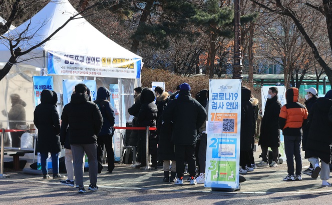 People wait in line to get COVID-19 tests at a makeshift virus testing clinic in Seoul on Dec. 25, 2021. (Yonhap)