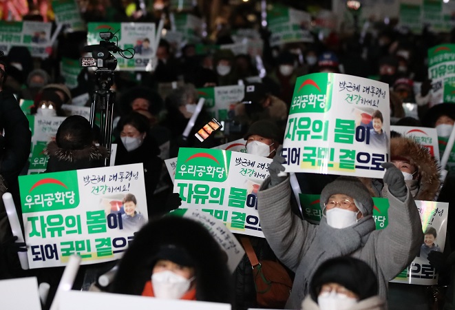 Supporters of former President Park Geun-hye celebrate her pardon in front of a hospital in central Seoul on Dec. 31, 2021. (Yonhap)