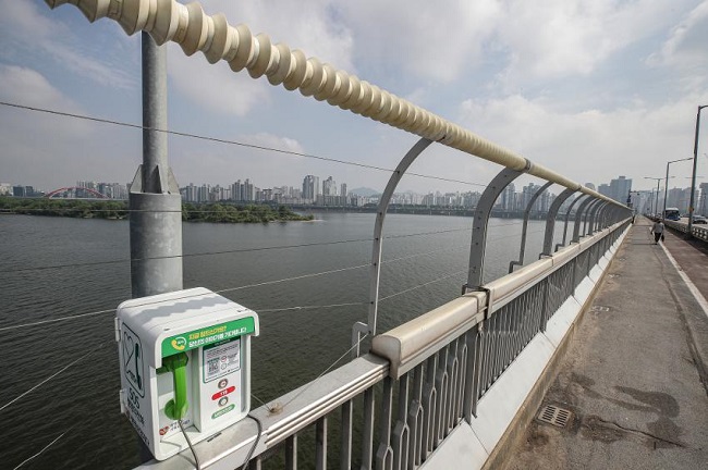This photo, taken on May 24, 2021, shows a special phone installed on Mapo Bridge over Seoul's Han River, which is a well-known suicide spot. The phone connects a person directly to crisis counseling as part of efforts to prevent suicide. (Yonhap)