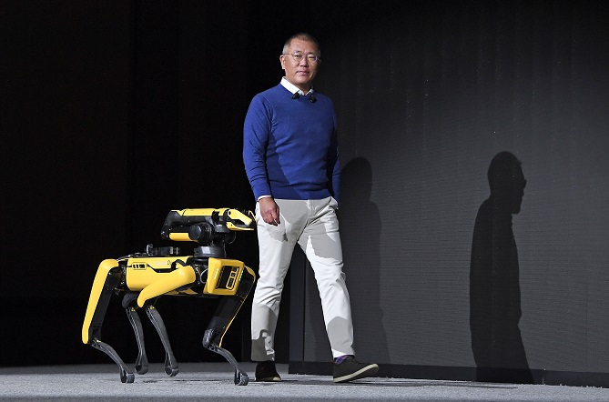 Hyundai Motor Group Chairman Euisun Chung enters a stage, along with Boston Dynamics' Spot robot, to announce the group's "metamobility" vision at CES 2022 on Jan. 4, 2021, in this photo provided by the group.