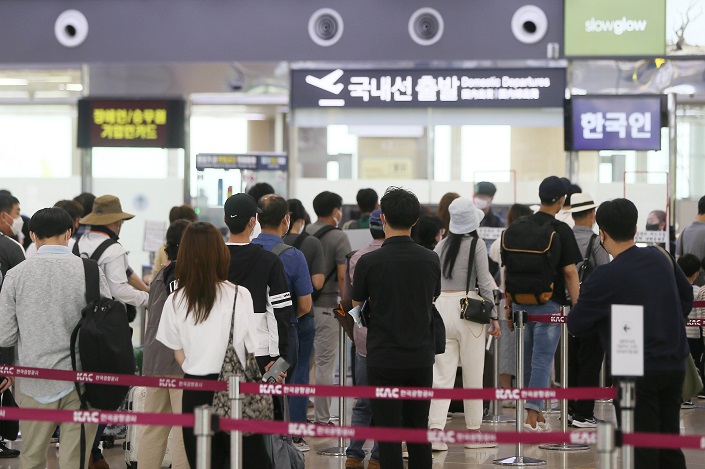 Travelers wait in line at Jeju International Airport on the southern resort island of Jeju during Chuseok, the Korean equivalent of Thanksgiving, in the file photo taken Sept. 21, 2021. (Yonhap)