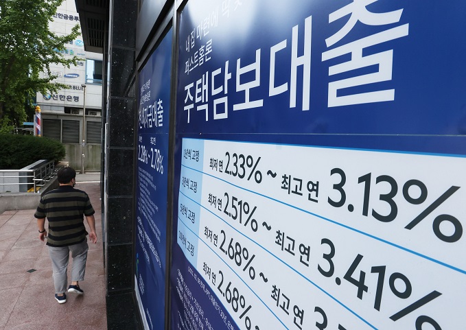 This file photo, taken Oct. 3, 2021, shows signs on a bank's loan programs that were put up on the exterior of a lender in Seoul. (Yonhap)
