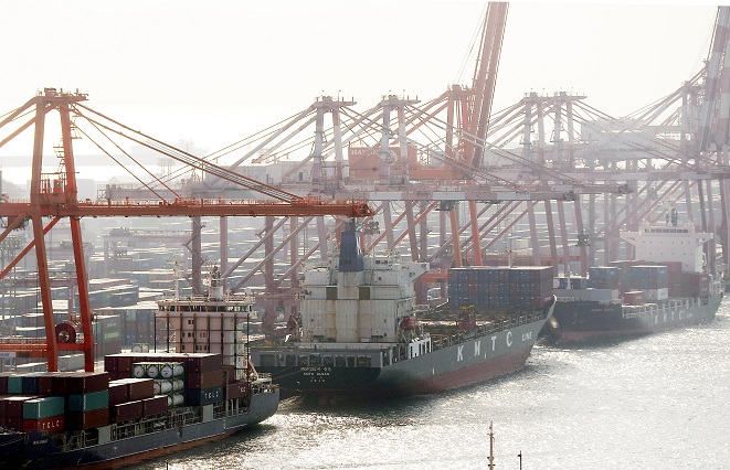 This file photo, taken Dec. 21, 2021, shows container ships being loaded with cargo at a port in South Korea's largest port city of Busan. (Yonhap)