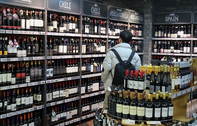 A shopper looks at a selection of wine at a large discount supermarket in Seoul on Jan. 5, 2022. (Yonhap)