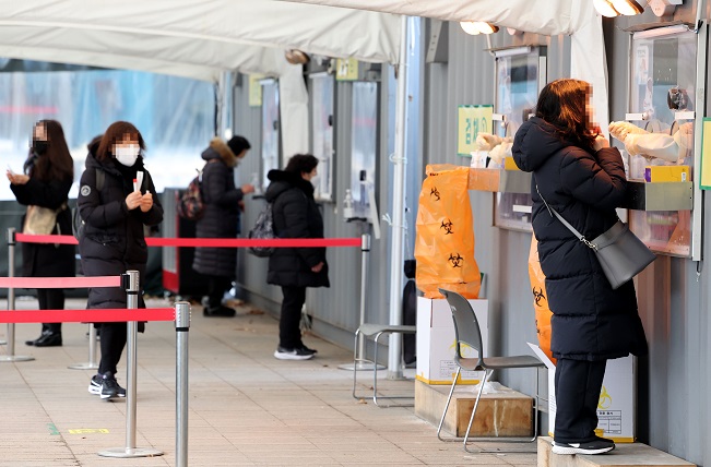 People take COVID-19 tests at a testing site near Seoul City Hall in Seoul on Jan. 15, 2022. (Yonhap)