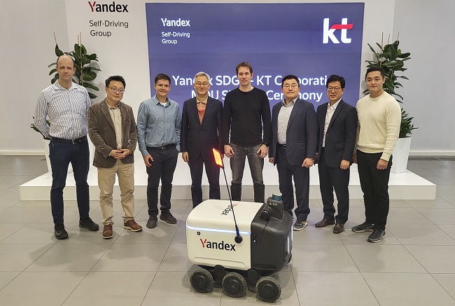 In this photo provided by KT Corp. on Jan. 18, 2022, AI/DX Convergence Business Division head Song Jae-ho (3rd from R) and Yandex SDG CEO Dmitry Polishchuk (4th from R) pose for a photo with other officials after signing a memorandum of understanding for a partnership in delivery robots.