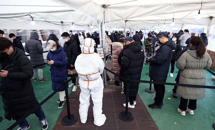 People wait in line to take COVID-19 tests at a makeshift testing booth in Seoul's eastern district of Songpa on Jan. 26, 2022. (Yonhap)