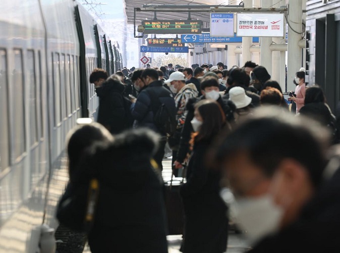 Travelers board a train at Seoul Station in central Seoul on Jan. 28, 2022, ahead of the extended Lunar New Year holiday. (Yonhap)