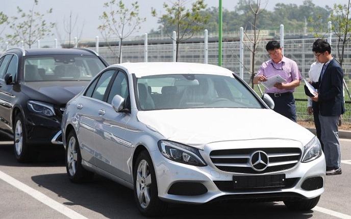 This file photo, taken on June 21, 2018, shows South Korean government officials checking a Mercedes-Benz car for a probe into alleged emissions rigging in the city of Hwaseong, Gyeonggi Province. (Yonhap)