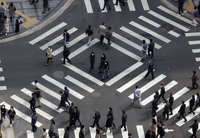 This March 26, 2021, file photo shows people crossing a street in Seoul. (Yonhap)