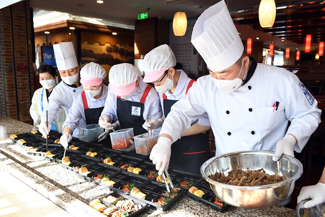 Chefs for the Korean Sport & Olympic Committee (KSOC) prepare boxed meals for South Korean athletes during the Beijing Winter Olympics inside a kitchen at Crowne Plaza Beijing Sun Palace Hotel in Beijing on Feb. 3, 2022, in this photo provided by the KSOC.