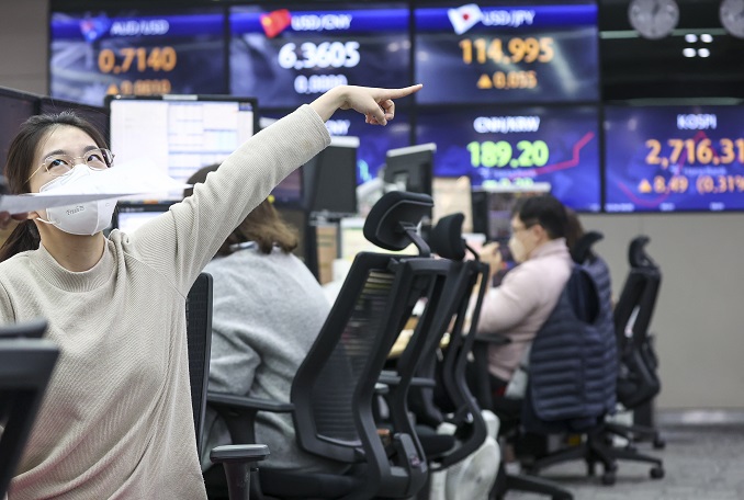 Currency traders work in the dealing room of Hana Bank in Seoul on Feb. 4, 2022. (Yonhap)