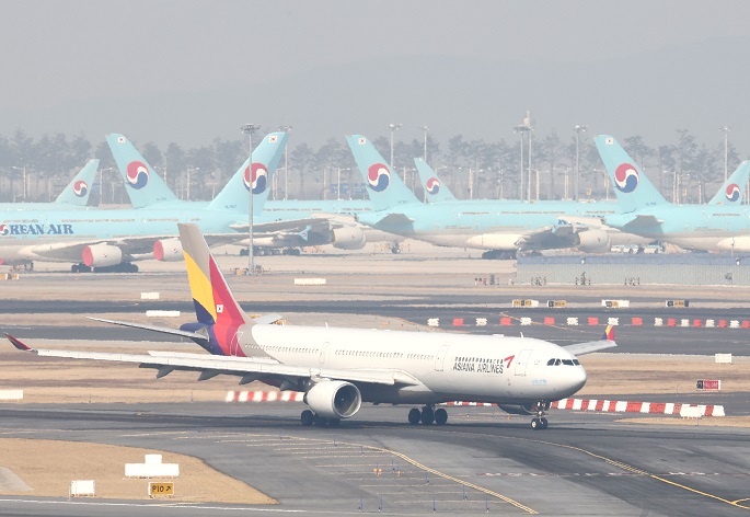 This file photo taken Feb. 9, 2022, shows an Asiana airplane along with many Korean Air planes at Incheon International Airport in Incheon, just west of Seoul. (Yonhap)