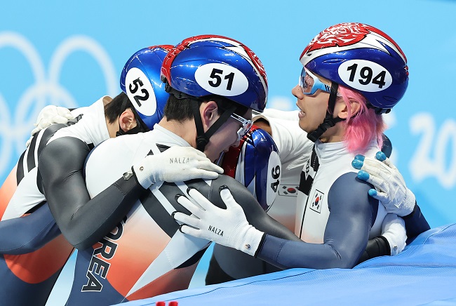 Kwak Yoon-gy of South Korea (R) is mobbed by teammates Kim Dong-wook, Hwang Dae-heon and Lee June-seo (L to R) after the team's victory in the men's 5,000m relay semifinal heat in short track speed skating during the Beijing Winter Olympics at Capital Indoor Stadium in Beijing on Feb. 11, 2022. (Yonhap)