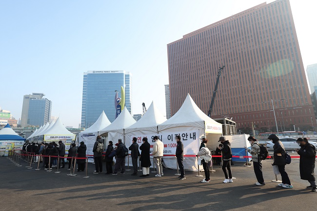 People wait in line to take COVID-19 tests at a makeshift testing center in front of Seoul Station in central Seoul on Feb. 12, 2022. South Korea recorded a daily high of 54,941 new COVID-19 infections, raising the total to 1,294,205, according to the Korea Disease Control and Prevention Agency (KDCA). (Yonhap)