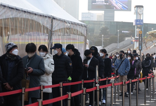 People wait in line to take COVID-19 tests at a makeshift testing center in front of Seoul Station in central Seoul on Feb. 12, 2022. South Korea recorded a daily high of 54,941 new COVID-19 infections, raising the total to 1,294,205, according to the Korea Disease Control and Prevention Agency. (Yonhap)