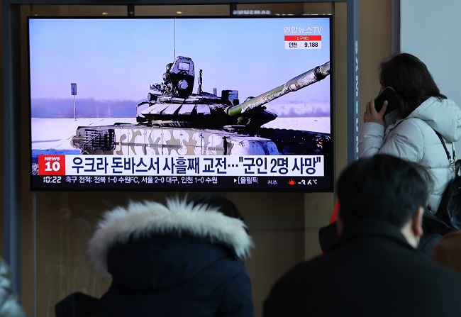 People watch a TV report on the Ukraine crisis at Seoul Station in central Seoul on Feb. 20, 2022. (Yonhap)