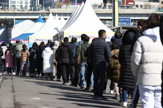 People line up to get tested for COVID-19 at a makeshift clinic in Seoul on Feb. 27, 2022. (Yonhap)