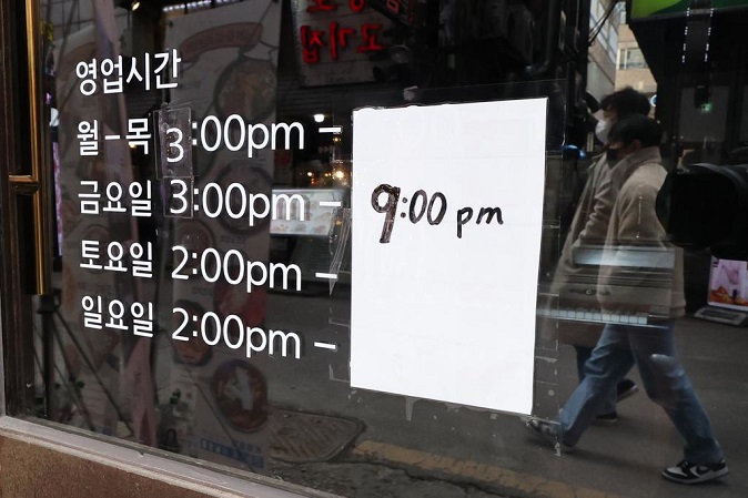 A notice posted at a restaurant in Seoul on Feb. 4, 2022, informs customers that operation hours last until 9:00 p.m. South Korea decided the same day to extend the current social distancing curbs for two more weeks through Feb. 20, during which private gatherings of more than six people will be banned and businesses are subject to a 9 p.m. curfew. (Yonhap)