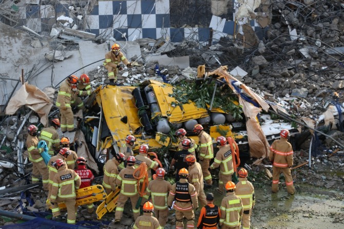 Firefighters carry out rescue operations after a 5-story building collapsed and fell on a bus and two passenger cars in the southwestern city of Gwangju on June 9, 2021. (Yonhap)