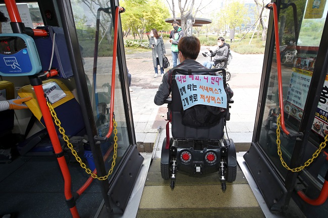 In this file photo, a handicapped activist gets off a bus in Gwangju, 330 kilometers south of Seoul, on April 20, 2020, while heading to a rally for rights improvement for disabled people. (Yonhap)