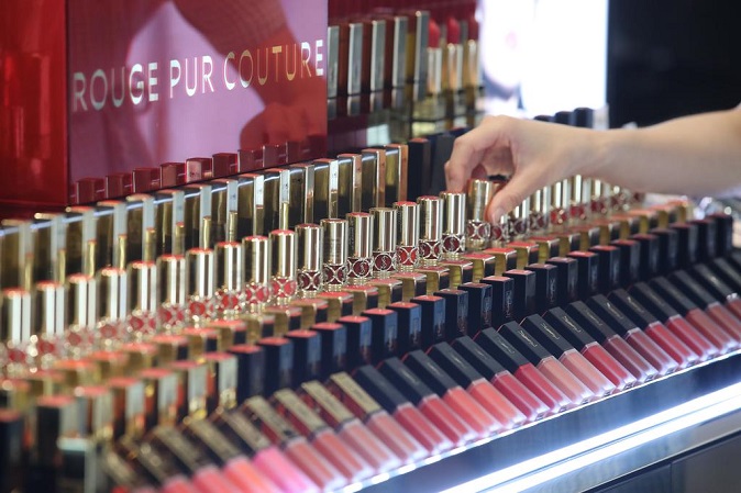A woman picks a lipstick at a department store in Seoul on July 1, 2021, amid growth of sales of color cosmetics in anticipation of mask-free days in line with the increase in vaccinations. (Yonhap)