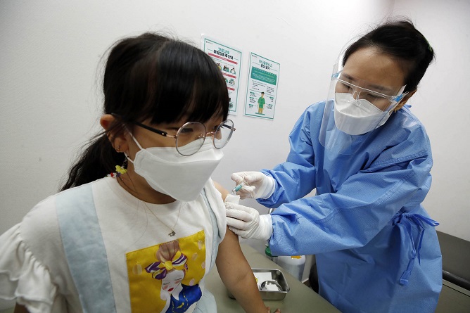 This image provided by a ward office in Gwangju shows a child getting a COVID-19 vaccine shot. 