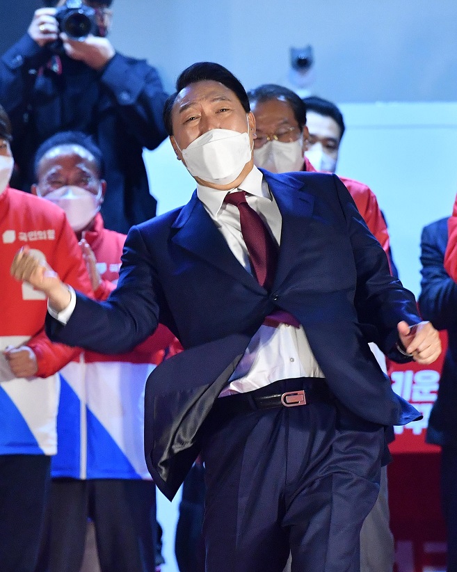 Yoon Suk-yeol of the main opposition People Power Party makes his signature uppercut gesture as he acknowledges his supporters in front of the party's headquarters in Seoul on March 10, 2022, after declaring victory in South Korea's presidential election. (Pool photo) (Yonhap)