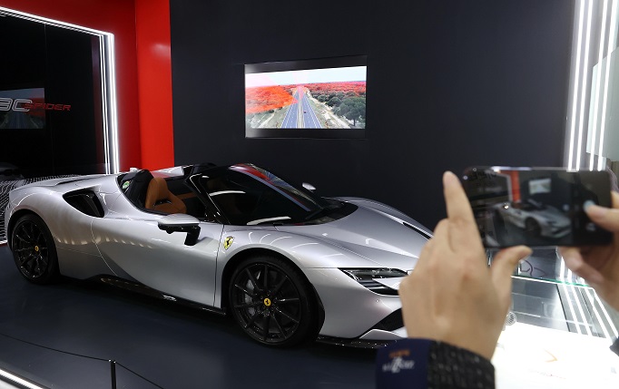 A visitor takes a photo of Ferrari's SF90 Stradale powered by South Korean battery maker SK On Co.'s product at InterBattery 2022, an international exhibition on rechargeable batteries, at COEX in Seoul on March 17, 2022. (Yonhap)