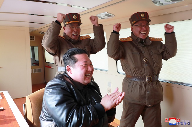 North Korean leader Kim Jong-un (front), accompanied by Jang Chang-ha (L, rear), chief of the North's Academy of National Defense, and Kim Jong-sik, the deputy director of the Munitions Industry Department, celebrates after a Hwasong-17 intercontinental ballistic missile (ICBM) was launched from Pyongyang International Airport on March 24, 2022, in this photo released by North Korea's official Korean Central News Agency.  (Yonhap)