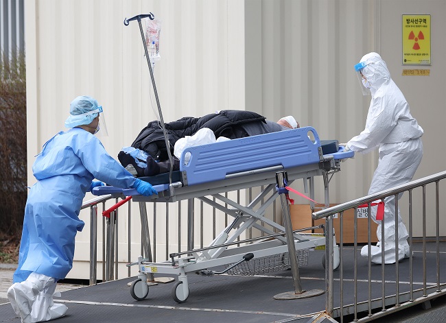 Medical workers move a COVID-19 patient at the Seoul Medical Center in central Seoul on March 25, 2022. (Yonhap)