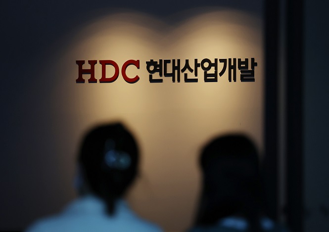 Workers enter the headquarters of HDC Hyundai Development Co. in Seoul on March 28, 2022. (Yonhap)