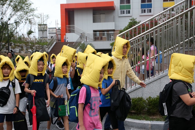 Students wearing safety hats evacuate from their classes during an earthquake drill at Chogok Elementary School in Pohang, some 370 kilometers southeast of Seoul, on Aug. 28, 2019. (Yonhap)