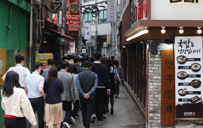 Office workers head to a restaurant near Seoul City Hall for lunch on April 14, 2022. (Yonhap)