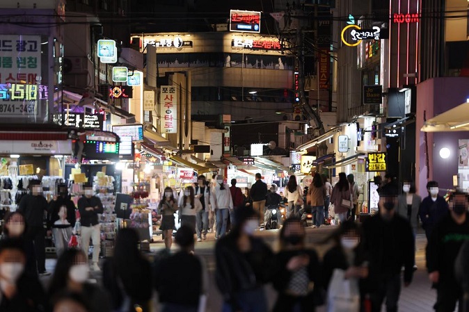 A street in Hongdae, one of the busiest entertainment districts in Seoul, is crowded with people on April 13, 2022, as South Korea moves to ease antivirus social distancing rules. (Yonhap)