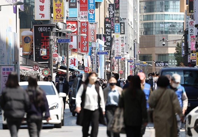 People walk down a street in central Seoul on April 15, 2022. (Yonhap)
