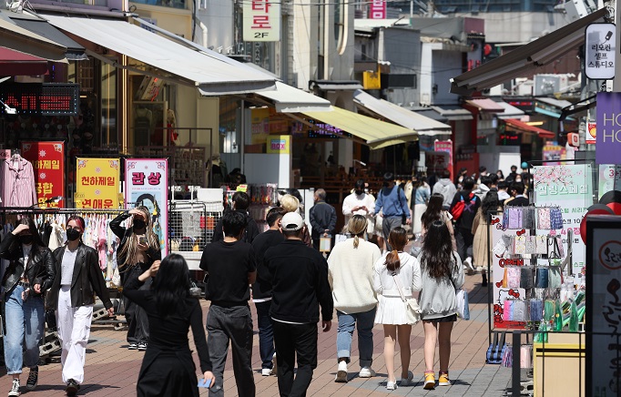 Citizens walk in the popular hangout spot of Hongdae, western Seoul, on April 16, 2022, as the government is set to lift almost all COVID-19 social distancing rules this week amid slowing infections. (Yonhap)