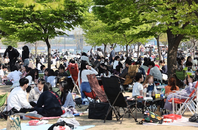 This photo shows people picnicking at Yeouido Han River Park on April 17, 2022. (Yonhap)