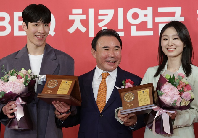 South Korean short track speed skaters Hwang Dae-heon (L) and Choi Min-jeong (R) pose with Genesis BBQ Chairman Yoon Hong-geun during a ceremony in Seoul on April 21, 2022, after receiving BBQ chicken coupons as rewards for winning gold medals at the 2022 Beijing Winter Olympics. (Yonhap)