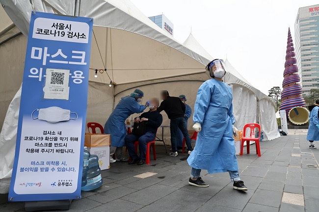 A Seoul citizen takes a COVID-19 test at a makeshift testing center at Cheonggye Stream, central Seoul, on April 24, 2022, amid the slowdown of the omicron wave. (Yonhap)