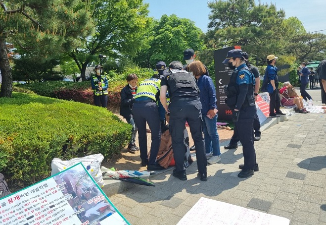 A one-person protester is stopped by police officers while trying to set up a tent near the presidential office building in Yongsan, central Seoul, on May 11, 2022. (Yonhap)