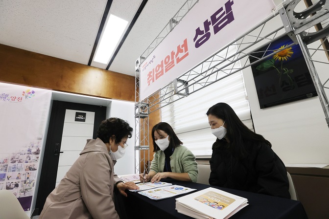 A senior citizen (L) receives job consulting at a job fair for the elderly in Seoul, in the file photo taken Nov. 9, 2021. (Yonhap)
